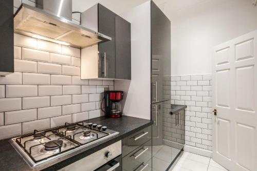 a kitchen with a stove top in a kitchen at Larger Groups Canary Wharf Apartment with Large Garden & Parking in London