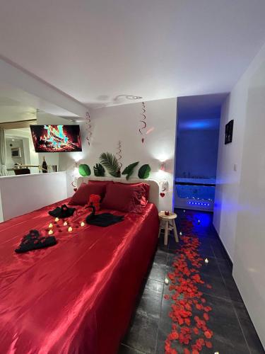 - une chambre avec un grand lit rouge et une couverture rouge dans l'établissement Beau gîte avec jacuzzi, à Barr