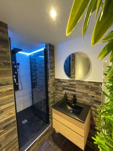 une salle de bain avec un lavabo noir et un miroir dans l'établissement Beau gîte avec jacuzzi, à Barr