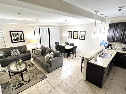 a kitchen and living room with a couch and a table at Cozy Family Town Home Close to Disney townhouse in Kissimmee
