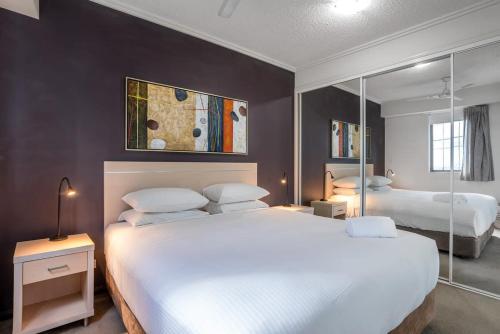 1 dormitorio con 2 camas y un cuadro en la pared en Skyline Sanctuary 1BR Apartment with River Views, en Brisbane