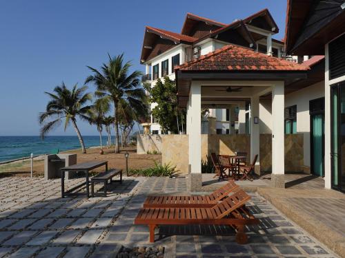 亞庇的住宿－Bonheur at Karambunai，海滩上带桌子和长椅的房子