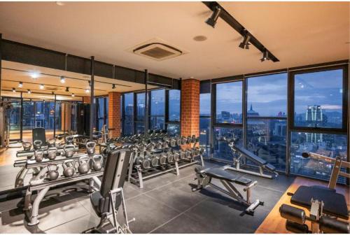 a gym with a lot of equipment and windows at Ceylonz Suites KL Tower View Bukit Bintang in Kuala Lumpur