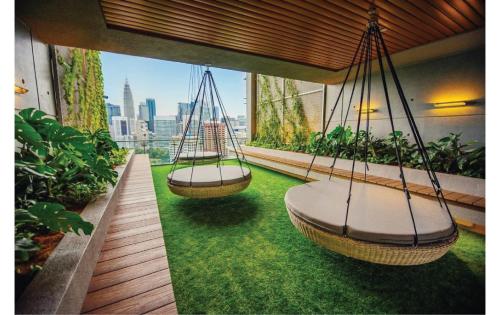 two swings hanging from a balcony with green grass at Ceylonz Suites KL Tower View Bukit Bintang in Kuala Lumpur