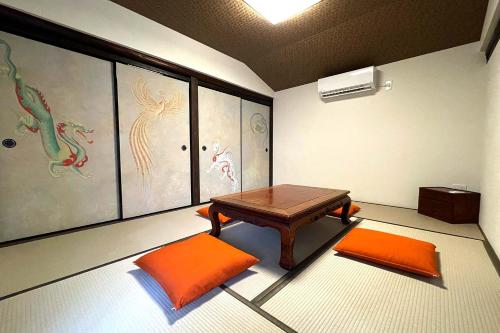 a room with a table and two orange chairs at Asuka no yado-明日香の宿- in Asuka