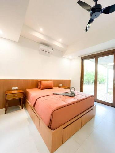 1 dormitorio con 1 cama y ventilador de techo en Villa Kamar Tamu Madurejo en Sleman