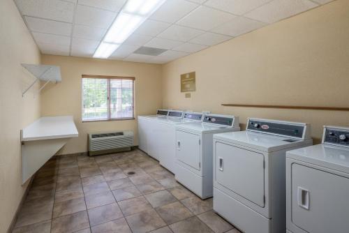 a laundry room with three washing machines and a window at Candlewood Suites New Bern by IHG in New Bern