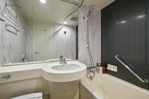 Hotel Villa Fontaine Tokyo-Jimbocho في طوكيو: حمام مع حوض ومرحاض وحوض استحمام