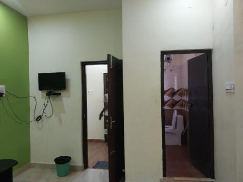 a room with a door and a television and a mirror at New greens inn in Yelagiri
