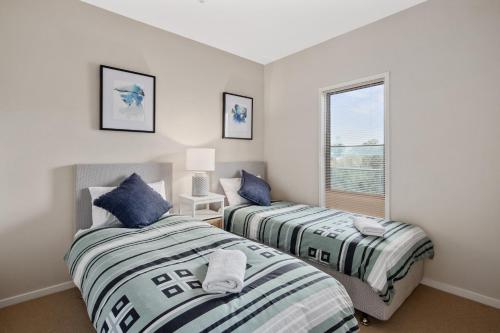 two beds in a room with a window at Ocean View Penthouse in Cowes