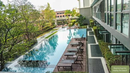 een zwembad aan de zijkant van een gebouw bij Rooms bangkok nearby Onnut bts in Amphoe Phra Khanong