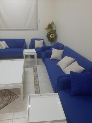 a living room with a blue couch and a table at حي الملك فهد in Ad Dawādimī