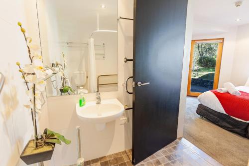 a bathroom with a sink and a toilet and a bed at Powder 2A in Thredbo