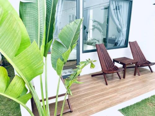 2 sedie e un tavolo su una terrazza in legno di Villa 3 Room Phan Thiết a Phan Thiet