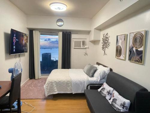 une chambre avec un lit, un canapé et une fenêtre dans l'établissement Condo near St Lukes and US Embassy in Ermita Manila, à Manille