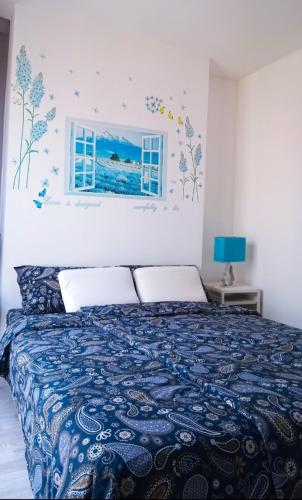 a bedroom with a bed with a blue bedspread and a window at Rooms bangkok nearby Onnut bts in Amphoe Phra Khanong