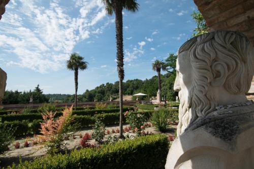 a statue of a head in a garden with palm trees at Villa Cattani Stuart XVII secolo in Pesaro