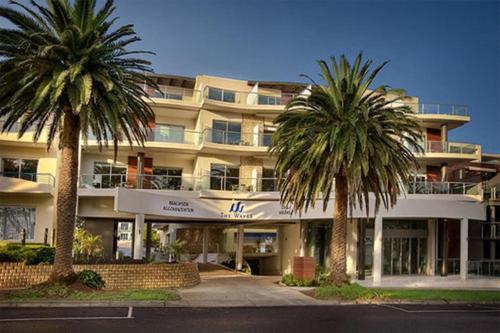 un hotel con dos palmeras delante en Ocean View Penthouse by Ready Set Stay, en Cowes