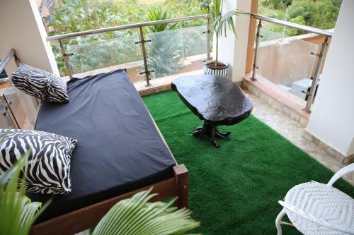 モンバサにあるNYALI FURNISHED APARTMENT WITH SWIMMING POOLのバルコニーと緑のカーペットが敷かれた部屋