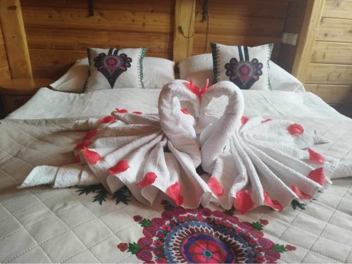 two swans are sitting on top of a bed at Krynicka Koliba na Jaworzynie Krynickiej in Krynica Zdrój