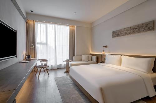 a hotel room with a large bed and a tv at Sahe Hotel Shanghai World Expo in Shanghai