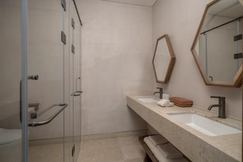 a bathroom with two sinks and a mirror at Sahe Hotel Shanghai World Expo in Shanghai