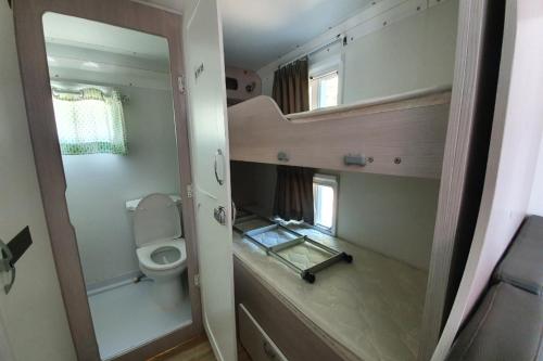 a small bathroom with a toilet and a mirror at Byeonsan Auto Camping in Buan