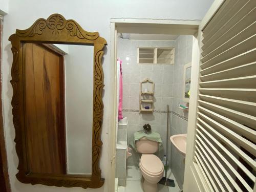 a small bathroom with a toilet and a mirror at Casa Vecina Hostal in Santa Marta
