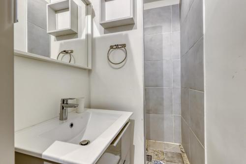 une salle de bain blanche avec un lavabo et une douche dans l'établissement Tranquil Heaven up to 4 guests - Heart of Paris 07, à Paris