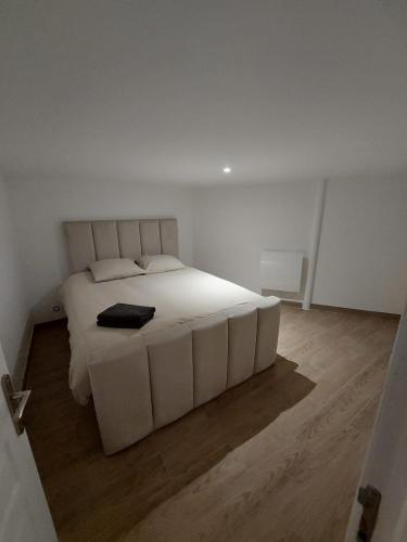 - un lit blanc dans une chambre blanche dotée de parquet dans l'établissement Livry09 Villa Dengous - Cozy Aéroport CDG Wifi 4 pers, à Livry-Gargan
