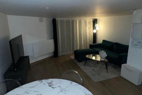 uma sala de estar com um sofá e uma mesa em Livry09 Villa Dengous - Cozy Aéroport CDG Wifi 4 pers em Livry-Gargan
