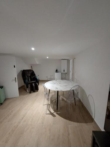 une chambre blanche avec une table au milieu d'une pièce dans l'établissement Livry09 Villa Dengous - Cozy Aéroport CDG Wifi 4 pers, à Livry-Gargan