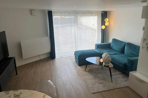 uma sala de estar com um sofá azul e uma mesa em Livry09 Villa Dengous - Cozy Aéroport CDG Wifi 4 pers em Livry-Gargan