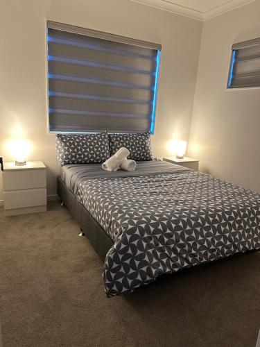 a bedroom with a bed with a teddy bear on it at 2 Bedrooms in Flat Bush in Auckland