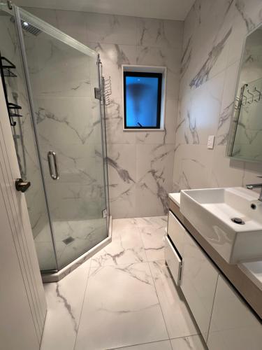 a bathroom with a shower and a sink at 2 Bedrooms in Flat Bush in Auckland