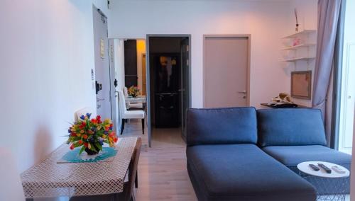 a living room with a blue couch and a table at Rooms bangkok nearby Onnut bts in Amphoe Phra Khanong