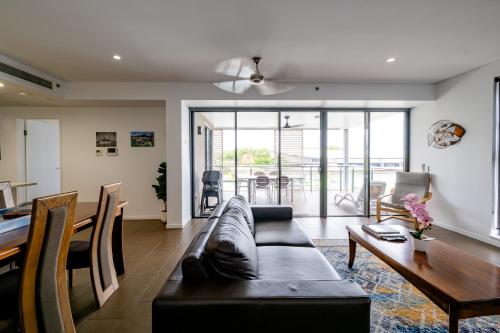 a living room with a couch and a table at Serenity Neptuna - 3brm luxury at Darwin Waterfront in Darwin