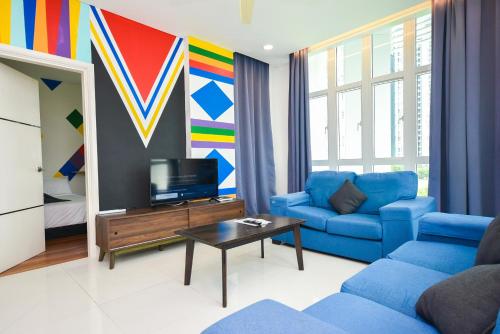 a living room with a blue couch and a tv at 1Medini Theme Suite by Nest Home【LEGOLAND】 in Nusajaya