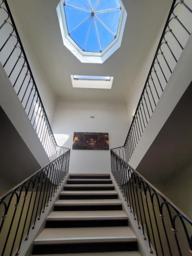 a staircase with a skylight in a building with a window at KYRIAD ORANGE Centre Ville - HOTEL & RESTAURANT & BAR - La Galerie d'Art des Princes - Provence Alpes Côte d'Azur - France - Proche A7-A9 - exit21- Châteauneuf-du-Pape Avignon Bollene Nimes - 24h-24h in Orange