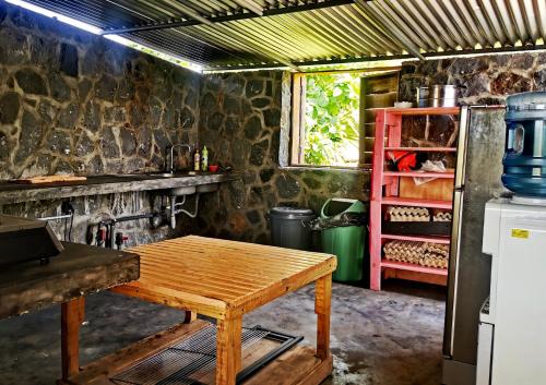 a kitchen with a wooden table and a refrigerator at Panoramic Paradise in Rodrigues Island