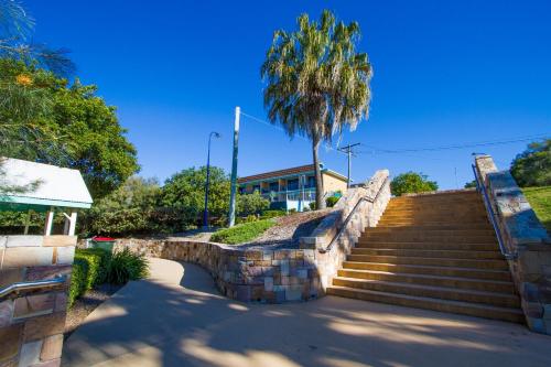 a set of stairs with a palm tree and a building at Tannum On The Beach Motel in Tannum Sands