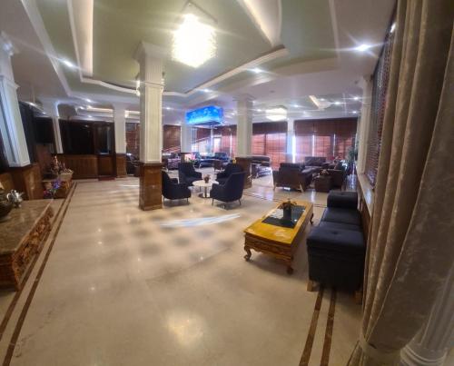 eine große Lobby mit Sofas und Stühlen in einem Gebäude in der Unterkunft Mentokling Residency, Leh, Ladakh in Leh