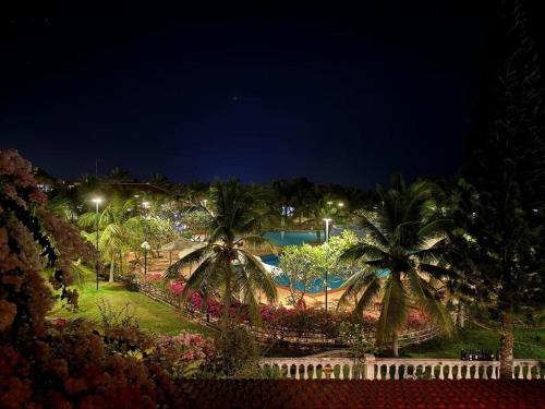 un parc avec des palmiers et une piscine la nuit dans l'établissement Biệt thự biển Mũi Né - Villa Muine Domaine - Sea View, à Phan Thiết