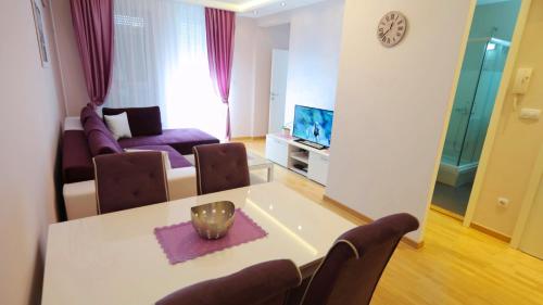 a living room with a table and a couch at Delta Residence Belville in Belgrade