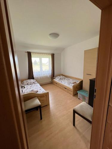 a small room with two beds and a window at Jendův domeček in Velká Jesenice