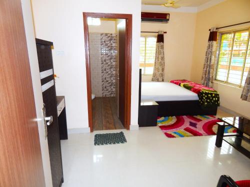 a bedroom with a bed and a door to a bathroom at Hotel PALKI Near Mandarmani Sea Beach in Mandarmoni