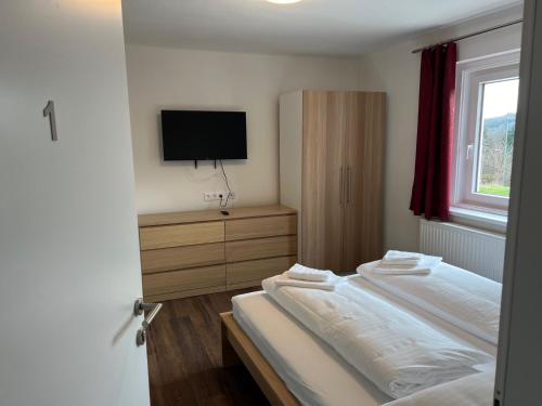 a bedroom with a bed and a flat screen tv at Klockerhof Appartements I Rooms in Hart bei Graz