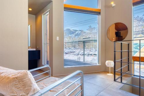 1 dormitorio con cama y ventana grande en Hakuba Jade Chalet by Jade Group, en Hakuba