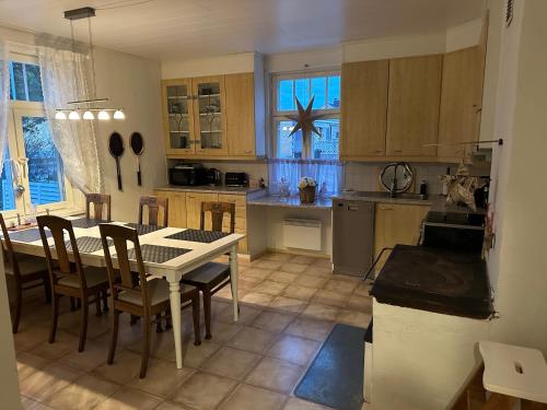 uma cozinha com uma mesa e algumas cadeiras e uma mesa e uma cozinha com em Koko talo & piha ulkopore-altaalla em Hanko