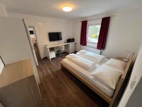 a bedroom with a bed and a desk with a television at Klockerhof Appartements I Rooms in Hart bei Graz